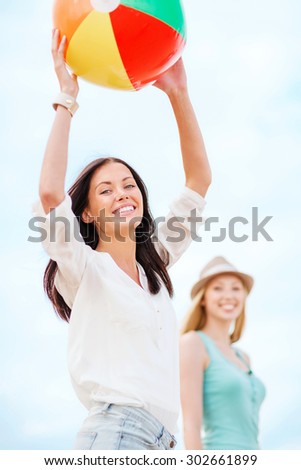 summer holidays, vacation and beach activities - girls playing ball on the beach