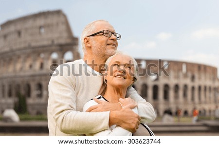 family, tourism, travel and people concept - happy senior couple over coliseum in rome, italy