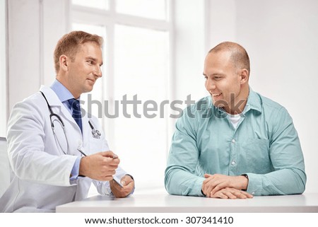 medicine, health care, people and prostate cancer concept - happy male doctor with clipboard and patient meeting and talking at hospital