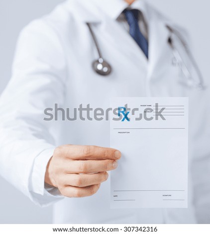close up of male doctor holding rx paper in hand