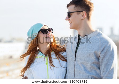 people, love and friendship concept - happy teenage couple walking in city