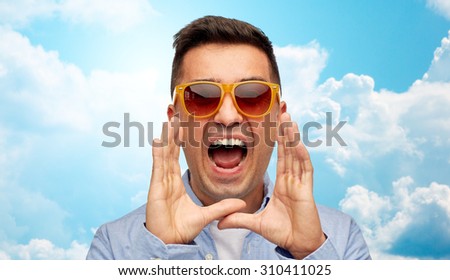 summer, emotions, communication and people concept - face of angry middle aged latin man in shirt and sunglasses shouting over blue sky and clouds background