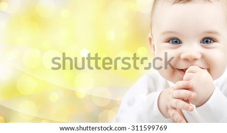 people, children and babyhood concept - close up of of happy baby over yellow background