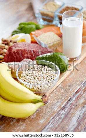 balanced diet, cooking, culinary and food concept - close up of vegetables, fruits and beans on wooden table