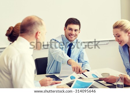 business, people and teamwork concept - smiling business team with papers meeting in office
