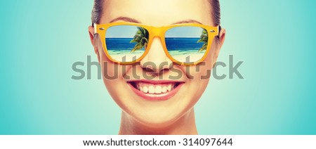 travel, vacation, summer holidays and happy people concept - portrait of happy teenage girl in sunglasses with beach reflection