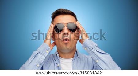 summer, emotions, style and people concept - face of scared or surprised middle aged latin man in shirt and sunglasses over blue background