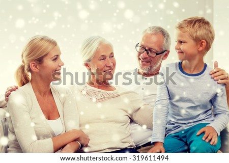 family, adoption, generation and people concept - happy family sitting on couch at home