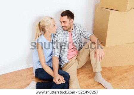 home, people, repair, moving and real estate concept - happy couple with many cardboard boxes sitting on floor at new place