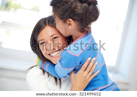 family, children, love and happy people concept - happy mother and daughter hugging at home
