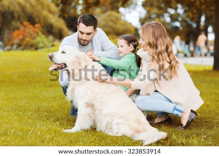 family, pet, domestic animal, season and people concept - happy family with labrador retriever dog on walk in autumn park