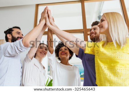 business, startup, gesture, people and teamwork concept - happy creative team making high five in office