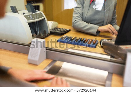 people, money, saving and finance concept - clerk counting coins for customer at bank office or currency exchanger Stock foto © 