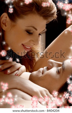 picture of sweet couple cuddling in bed with flowers