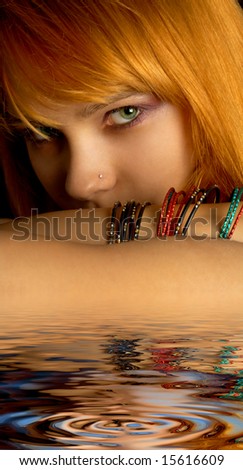 dark portrait of lovely redhead in water