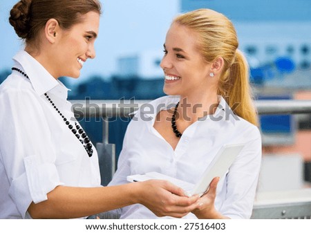 two happy businesswomen with laptop computer (focus on brunette)
