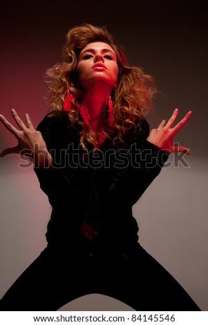 picture of fashionable woman in black clothes in red light