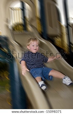 Little boy playing on the slide