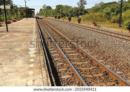 Similar – Foto Bild Gleisbett einer wenig benutzten Bahnstrecke, am Rand kahle Bäume. Schwarzweiß-Aufnahme.