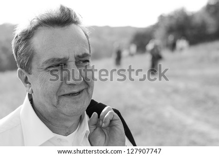 Outdoor closeup portrait of a confident mature business man. Black and white photo.