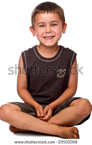 Smiling Young Caucasian Boy Sitting With His Legs Crossed On A White ...
