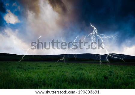 Thunderstorm with lightning in green meadow