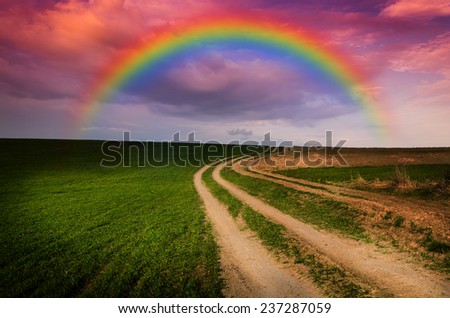 Dirt road and rainbow in the night. Elements of this image furnished by NASA.