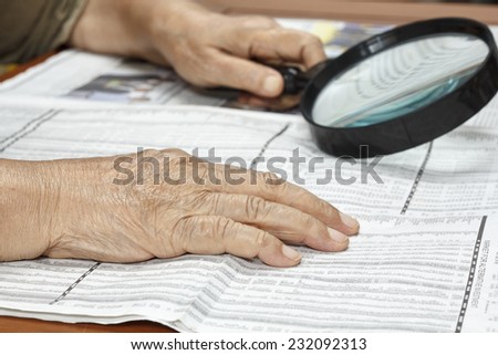Senior woman reading stock listings