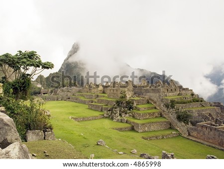 View of the lost city of Machu Picchu near Cusco, Peru underneath the cover of fog.