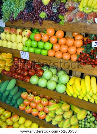 Variety of fruits and vegetables at fruit stand at Thai weekend market.