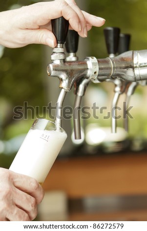 Similar – Image, Stock Photo A fresh beer (Kölsch) is tapped at the tap in a bar