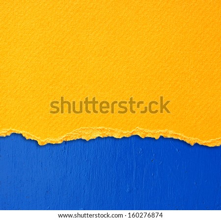 yellow textured torn paper over blue wall background