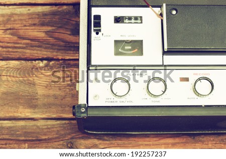 Old portable reel to reel tube tape-recorder, toned image, over wooden background