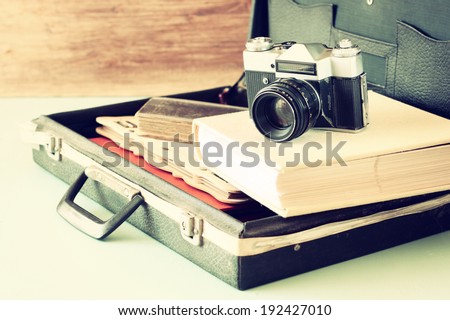 old case with books and vintage camera on top. travel or adventure concept
