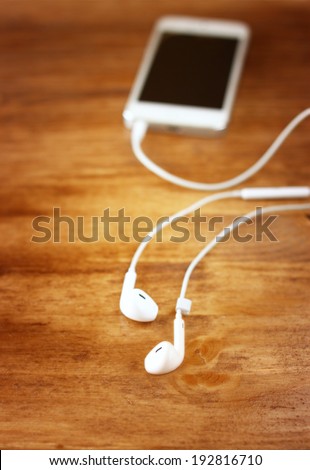 white earphones attached to smartphone. selective focus on earphones,