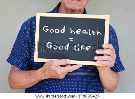close up of senior man holding a blackboard with the phrase good health equals good life