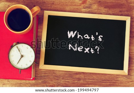 clock, coffee, and blackboad with the phrase whats next? written on it.