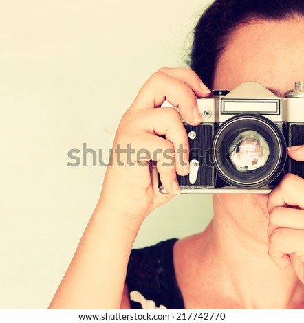 young woman holding old camera. vintage effect