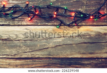 Colorful Christmas lights on wooden  rustic background. retro filtered image