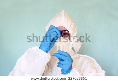 Lab scientist in safety suit With in test tube. selective focus