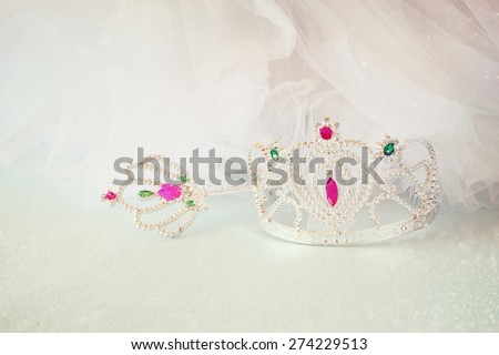 Little girls shiny crown and magic wand and chiffon dress with glitter overlay. selective focus
