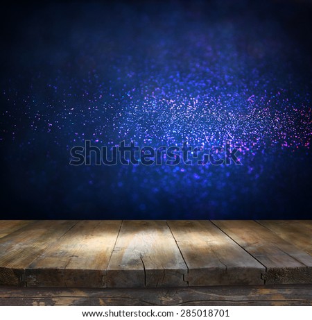 rustic wood table in front of glitter silver, blue, and gold bokeh lights