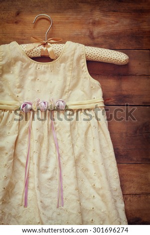 vintage cream girl\'s dress on hanger with on wooden background