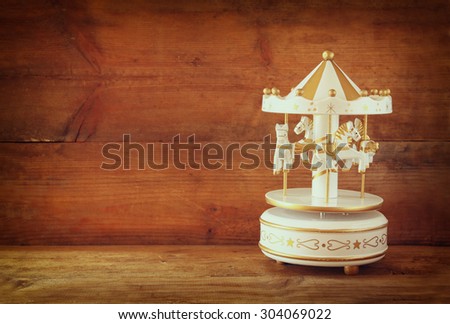 old vintage white carousel horses on wooden table. retro filtered image