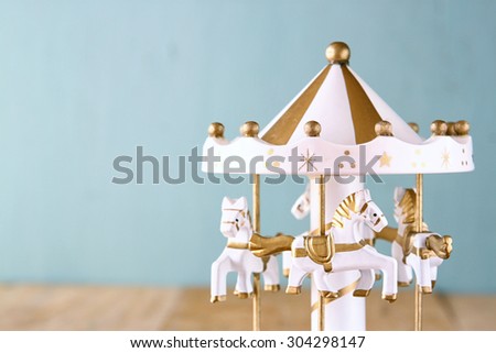 old vintage white carousel horses on wooden table