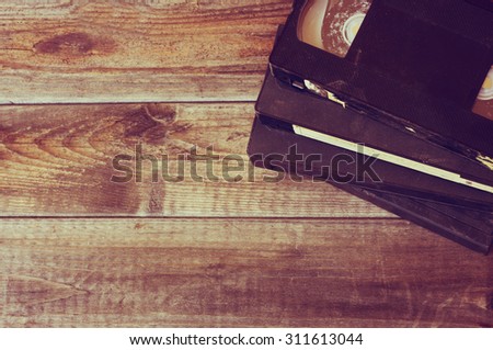 stack of VHS video tape cassette over wooden background. top view photo