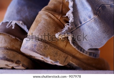 pair of old muddy construction boots on laborer