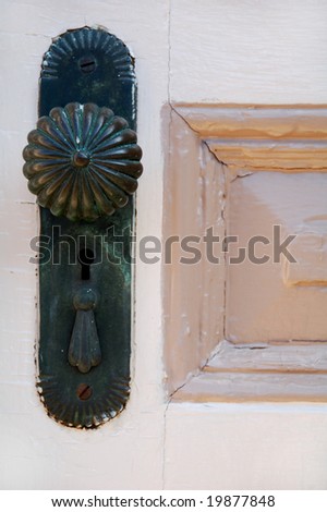 antique doorknob on old wooden door with panel