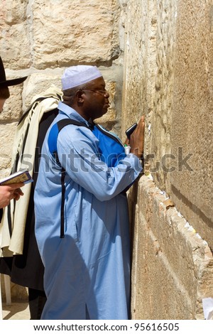 JERUSALEM - MARCH 09: An unidentified religious tourist from Africa wearing a prayer shawl draped over his shoulders prays near the Wailing Wall in the Old City of Jerusalem, March 09, 2007.