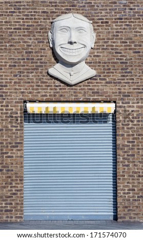 BROOKLYN, NEW YORK - OCTOBER 27 : Garage door at a old brick wall building with smiling face sculpture on October 27, 2013 at Coney Island, New York.